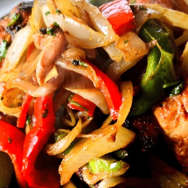 Close-up of Everest Restaurant's Indian dish with sautéed onions, red and green bell peppers.